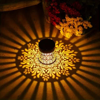 Applique solaire pivoine allumée projetant un motif lumineux décoratif