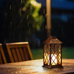 Lanterne solaire à LED effet flamme présentée sur une table de terrasse mouillée